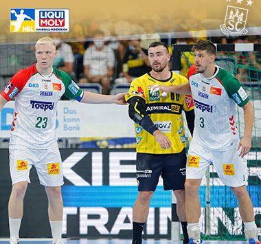 Zwei Spieler des SC Magdeburg verteidigen im weißen Trikot gegen die Rhein-Neckar Löwen.