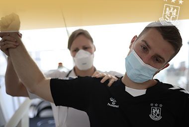 Lukas Mertens absolviert mit medizinischer Maske eine Untersuchung beim Medizincheck.