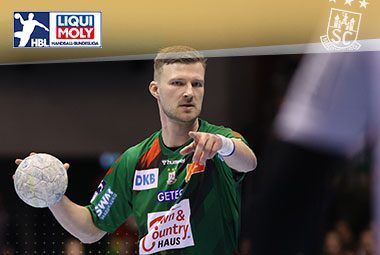 Philipp Weber läuft im grün-roten SCM-Trikot mit dem Handball in der Hand auf dem Feld.