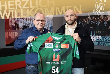Neuzugang Oscar Bergendahl präsentiert bei seiner Vorstellung das grüne SCM-Trikot mit der Rückennummer 54 neben einem Vereinsverantwortlichen.