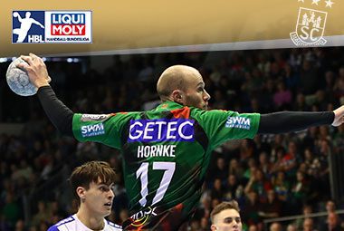 Tim Hornke holt im grünen SCM-Trikot mit der Rückennummer 17 von hinten am Ball zum Wurf aus.