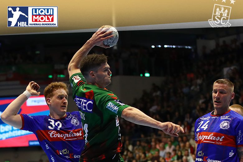 Kay Smits im grünen SCM-Trikot setzt am Ball im Sprungwurf zum Angriff an gegen zwei Abwehrspieler des Bergischen HC.