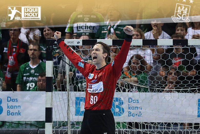 Torwart Nikola Portner vom SC Magdeburg jubelt mit erhobenen Armen im roten Trikot vor dem Handballtor.