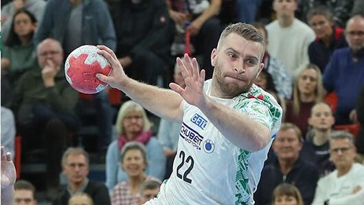 Handballspieler Mertens vom SC Magdeburg mit Rückennummer 22 wirft den Ball gegen GWD Minden.
