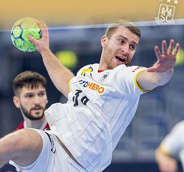 Lukas Mertens zieht im weißen Trikot der Nationalmannschaft im Sprungwurf ab.