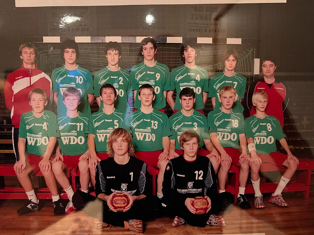 Historisches Mannschaftsfoto einer Jugendmannschaft des SC Magdeburg in grünen Trikots in einer Sporthalle.