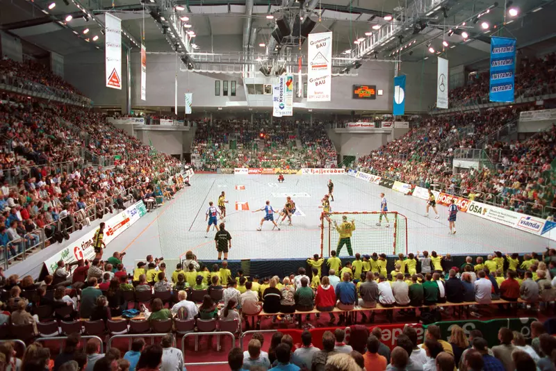 Blick von den Rängen auf das Spielfeld während eines vollbesetzten Handballspiels in der Hermann-Gieseler-Halle.