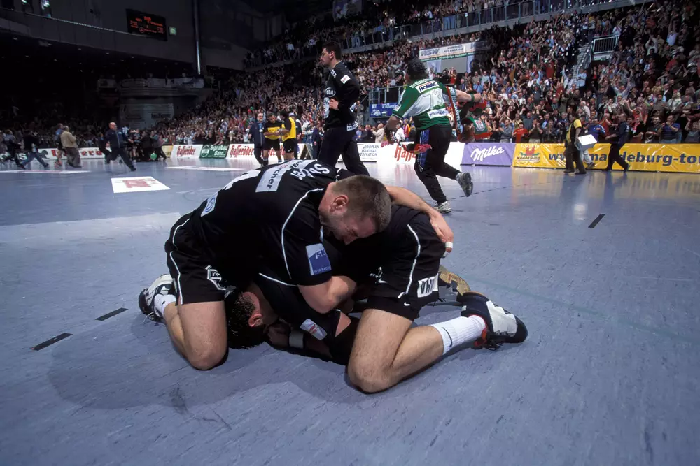 SCM-Handballer liegen sich nach dem Gewinn der deutschen Meisterschaft 2001 jubelnd auf dem Spielfeld in den Armen.