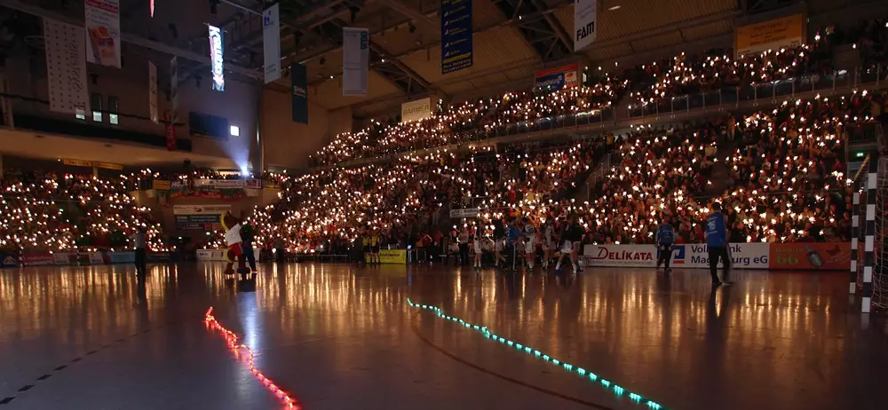 Historisches Foto einer Lichtershow der SCM-Fans in der verdunkelten Handballhalle.