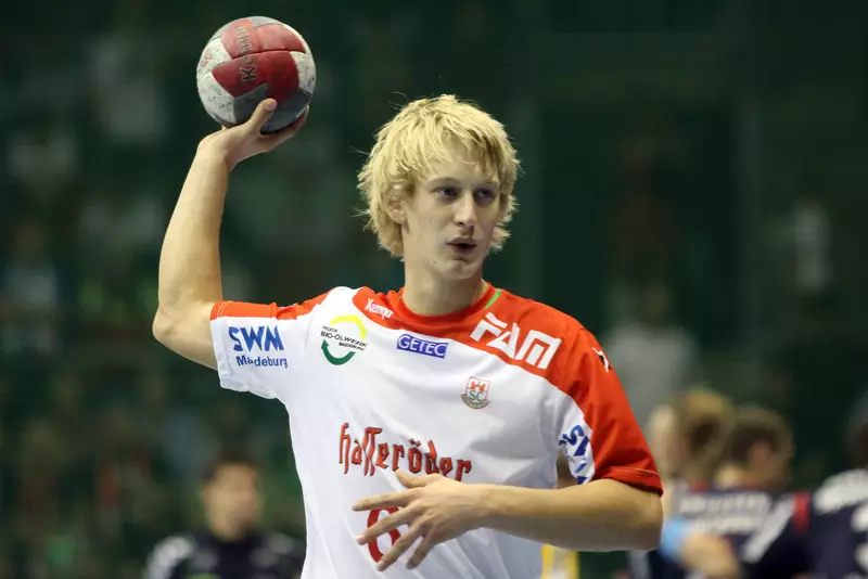 Der junge SCM-Spieler Matthias Musche mit erhobenem Handball blickt fokussiert auf das Spielfeld.