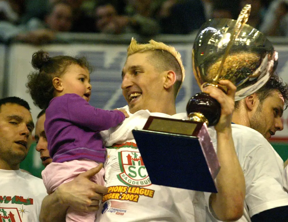 Seiner Tochter Lucie zeigt Handball-Nationalspieler Stefan Krezschmar den Pokal als Sieger der Handball Champions League während der Siegerehrung in Magdeburg am Samstag, 27. April 2002.